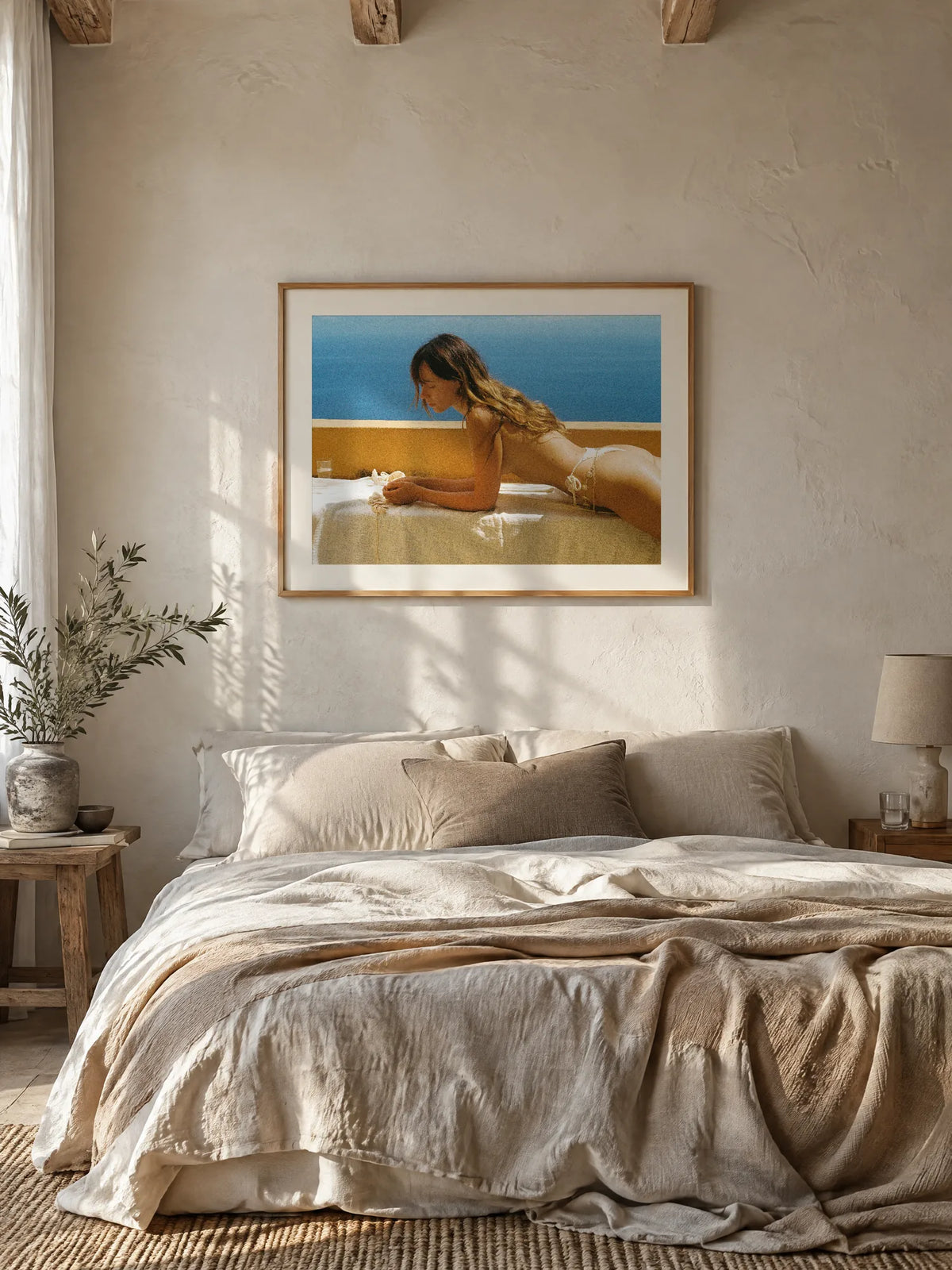 Blue Terrace by Wam Ornelas, framed in natural oak with a white mat (32 × 24 in), above a linen bed
