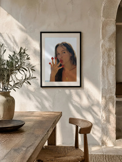 Raspberries by Wam Ornelas, framed in black oak with a white mat (24 × 32 in), above a wooden table